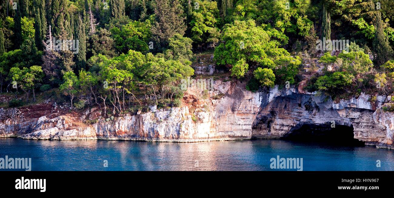 A coastal cave fringed by the beautiful azure waters of the Ionian Sea on the east coast of the Greek island of Kefalonia. Stock Photo