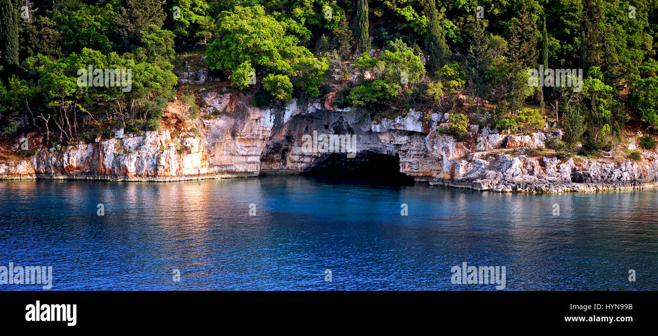 A coastal cave fringed by the beautiful azure waters of the Ionian Sea on the east coast of the Greek island of Kefalonia. Stock Photo