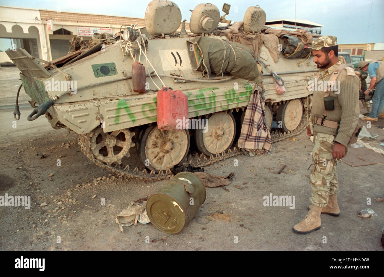 A Qatari soldier inspects an Iraqi armored personnel carrier destroyed by U.S Aircraft following the Battle of Khafji February 2, 1991 in Khafji City, Saudi Arabia. The Battle of Khafji was the first major ground engagement of the Gulf War. Stock Photo