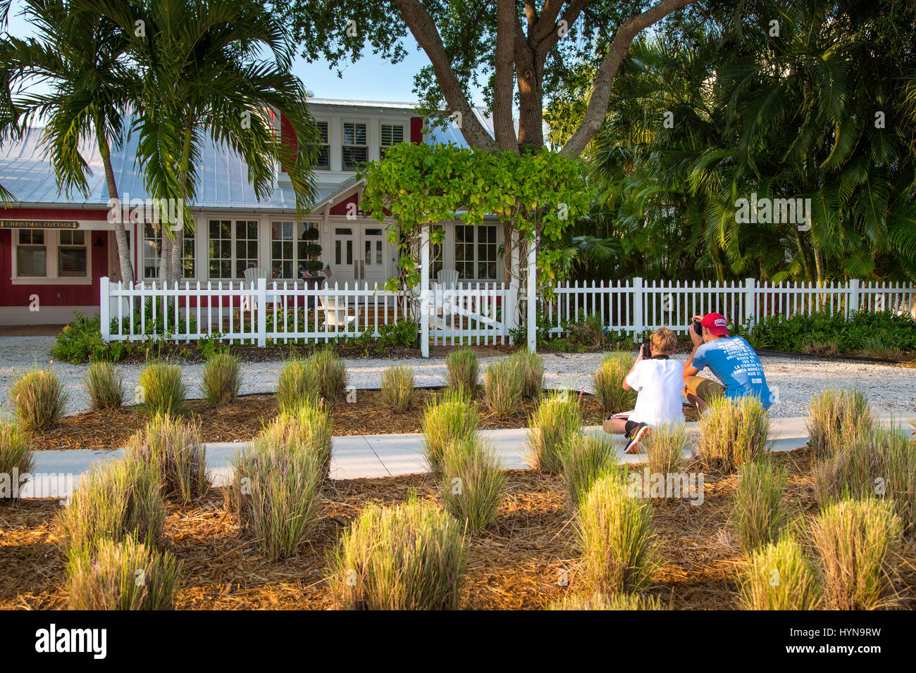 Two young photographers in front of Christmas Cottage (b 1902) - one of the historic cottages of Naples, Florida, USA Stock Photo