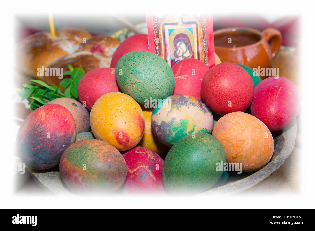 Colorful easter eggs in a ceramic bowl. Ritual bread. Stock Photo