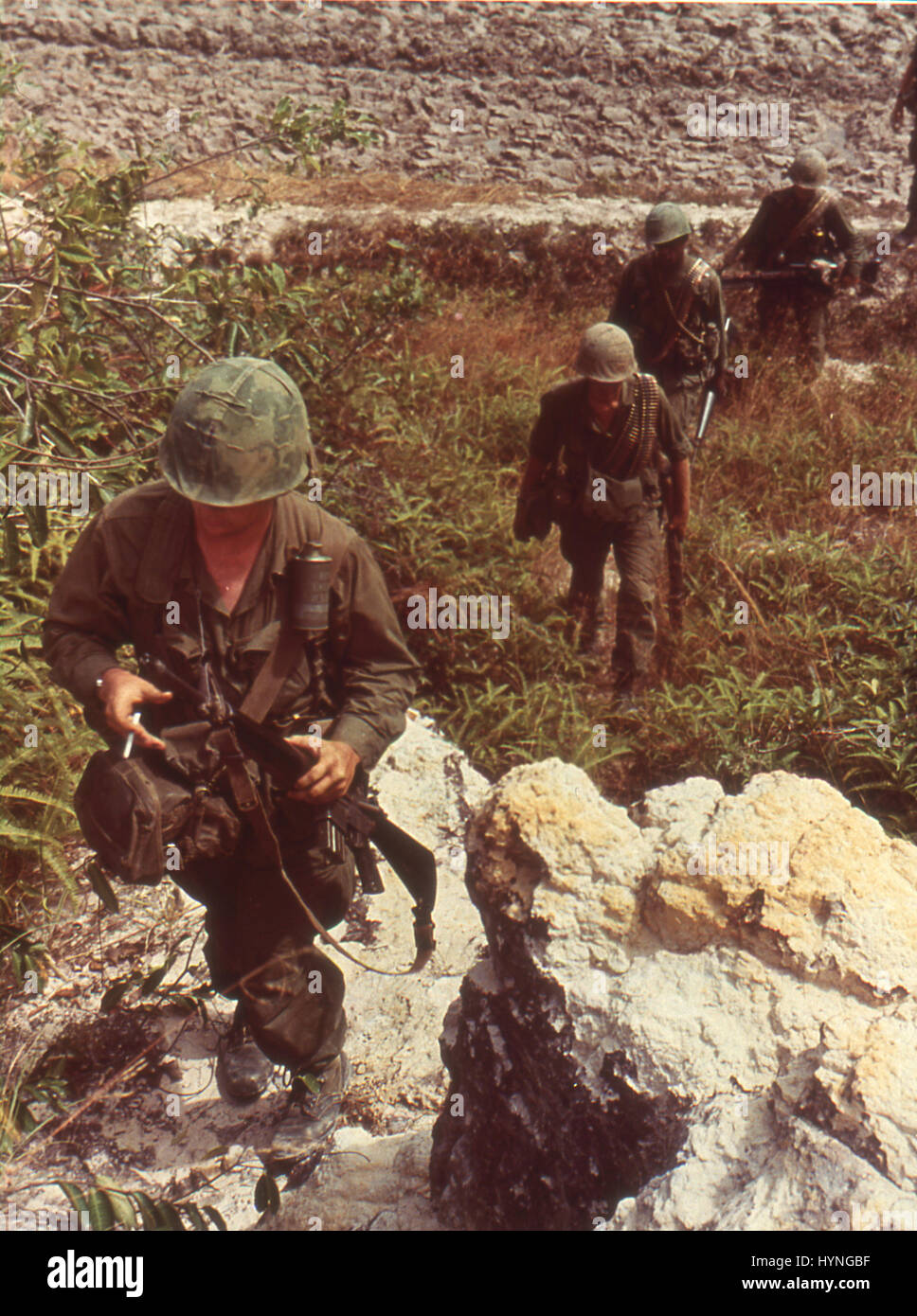 American patrol searches for Viet Cong in a rocky area near Saigon. Vietnam, 1967. Stock Photo