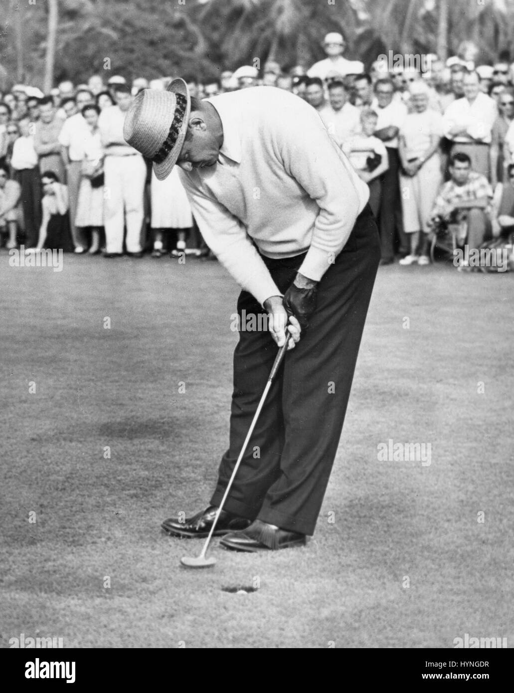 Sammy Snead sinks a putt to beat Tommy Bolt on the first hole of a playoff for the Miami Open Golf Tournament title. Miami, FL, 12/14/55. Stock Photo