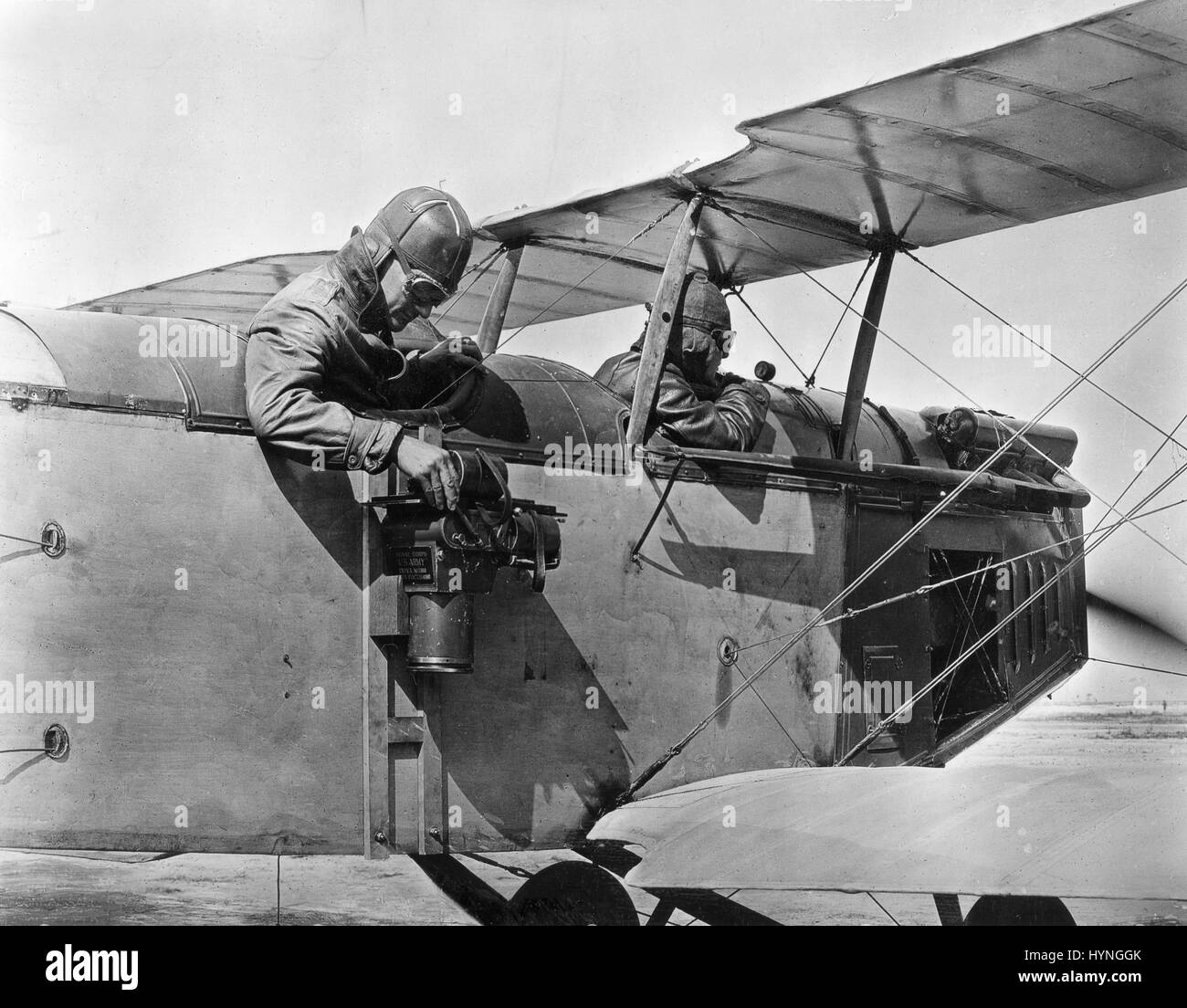 Photo shows a camera mounted on the side of a 1919 US Army plane. The first aerial cameras were modifications of existing plate cameras and were used for military reconnaissance and mapping during World War I. 1919. Stock Photo