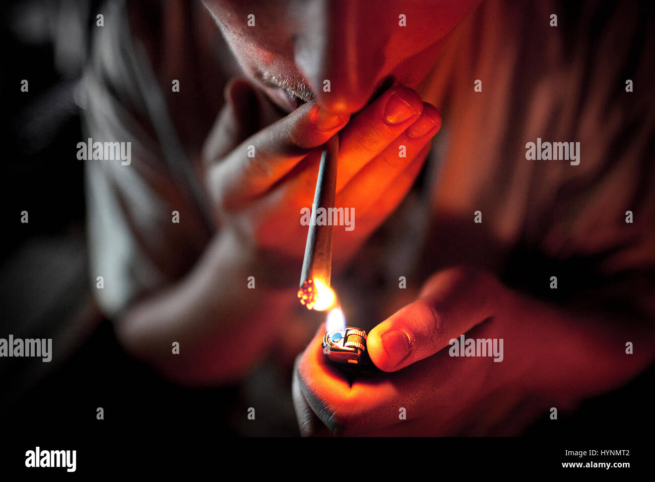 Young man lights up a marijuana joint Stock Photo Alamy