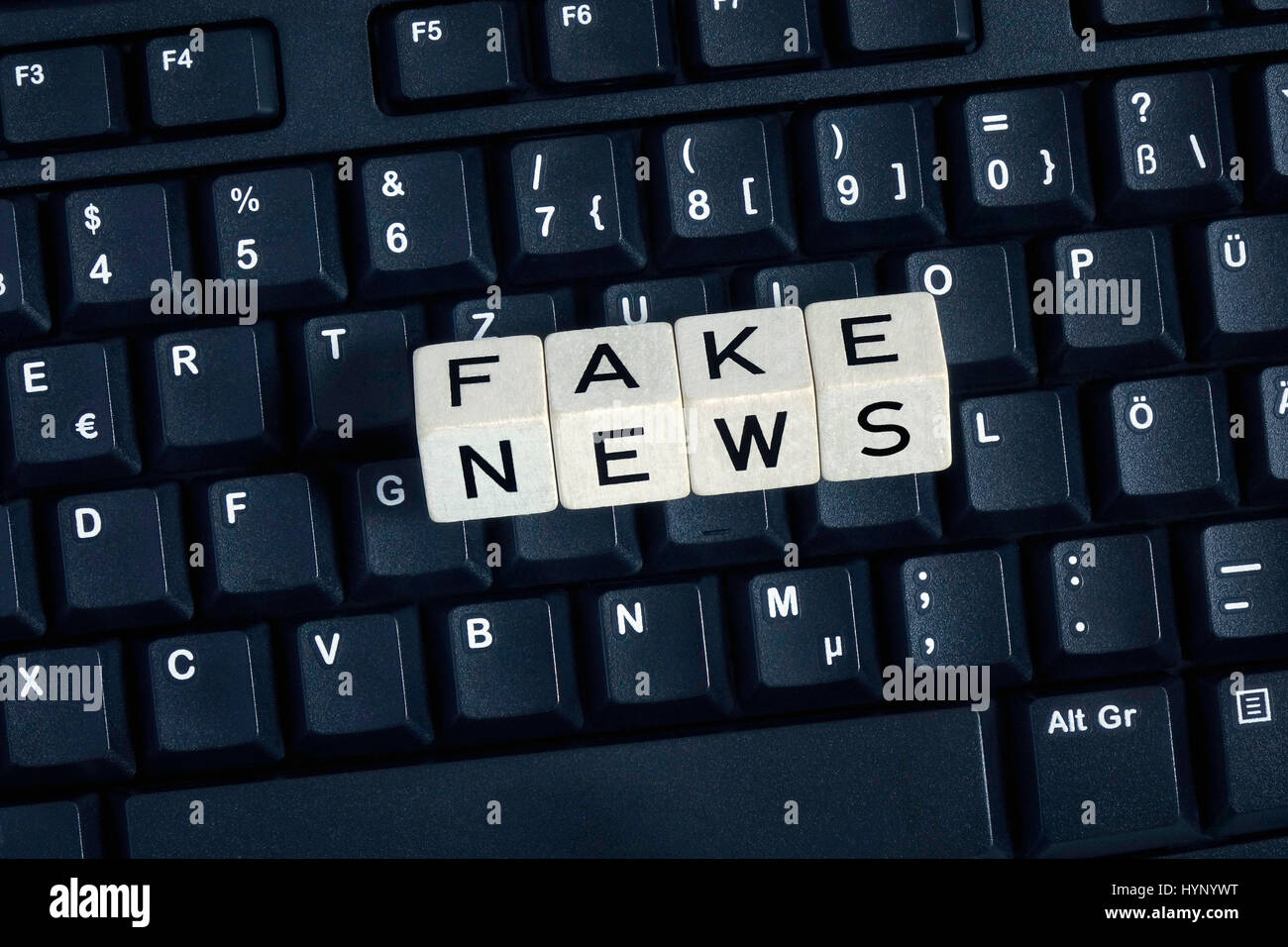 ILLUSTRATION - Four letter-dice spell out the words 'Fake News' on a computer keyboard. Taken on 18.12.2016. 'Fake News' refers to false and incorrect information, often spread on purpose via electronic channels (mainly social media). They are deliberately spread by journalists, office-holders, politicians, companies and private individuals. In the German language, the word 'fake' has no exact cognate, and the English word is increasingly used by internet users and as a result has developed an association with internet culture and online jargon. These days fake news stories (untrue information Stock Photo
