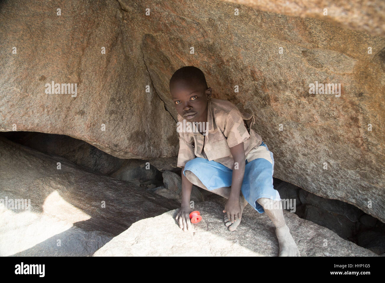 Kauda, Sudan. 12th Feb, 2017. A boy hides in a cave near Kauda, Sudan, 12 February 2017. The caves offer the population a refuge from the government's air force, which regularly conducts bombing raids using Soviet Antonov planes. The mountains are controlled by the national liberation army Sudan People's Liberation Army-North (SPLA-N) and its political arm, the Sudan People's Liberation Movement-North (SPLM-N). Photo: Laura Wagenknecht/dpa/Alamy Live News Stock Photo