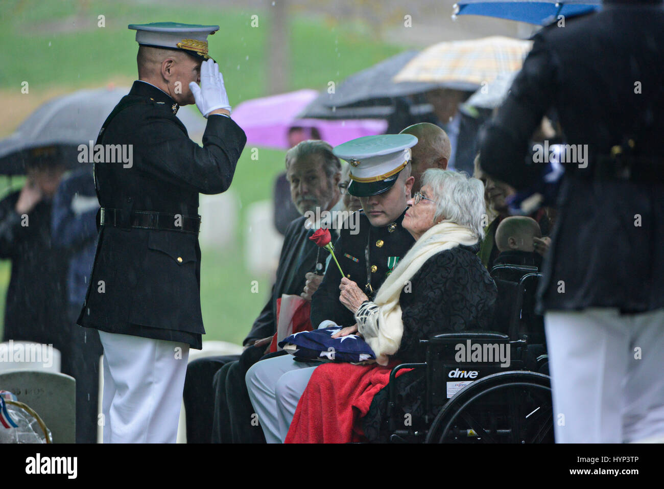 Arlington, Virginia, USA. 6th Apr, 2017. Commandant of the Marine Corps Gen. Robert Neller, left, salutes Annie Glenn, widow of John Glenn, after presenting her with the flag and a rose during the graveside service in Section 35 of Arlington National Cemetery April 6, 2017 in Arlington, Virginia. Glenn, the first American astronaut to orbit the Earth and later a United States senator, died at the age of 95 on December 8, 2016. Credit: Planetpix/Alamy Live News Stock Photo