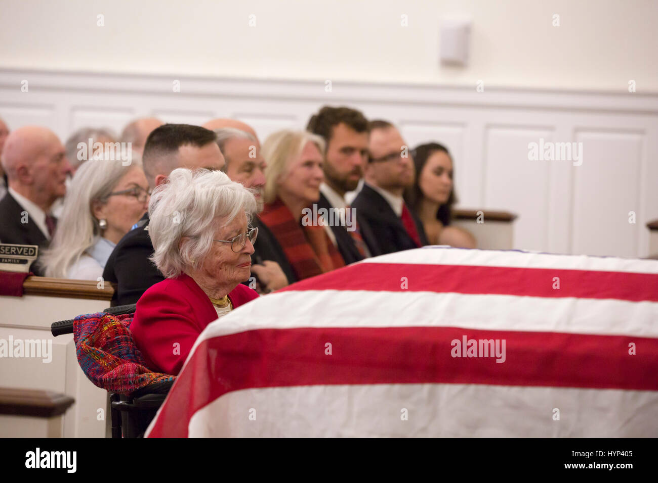 Arlington, Virginia, USA. 6th Apr, 2017. Annie Glenn, widow of John Glenn, sits by the flag draped casket of her husband during the funeral service at the Old Post Chapel, Ft. Meyer April 6, 2017 in Arlington, Virginia. Glenn, the first American astronaut to orbit the Earth and later a United States senator, died at the age of 95 on December 8, 2016. Credit: Planetpix/Alamy Live News Stock Photo