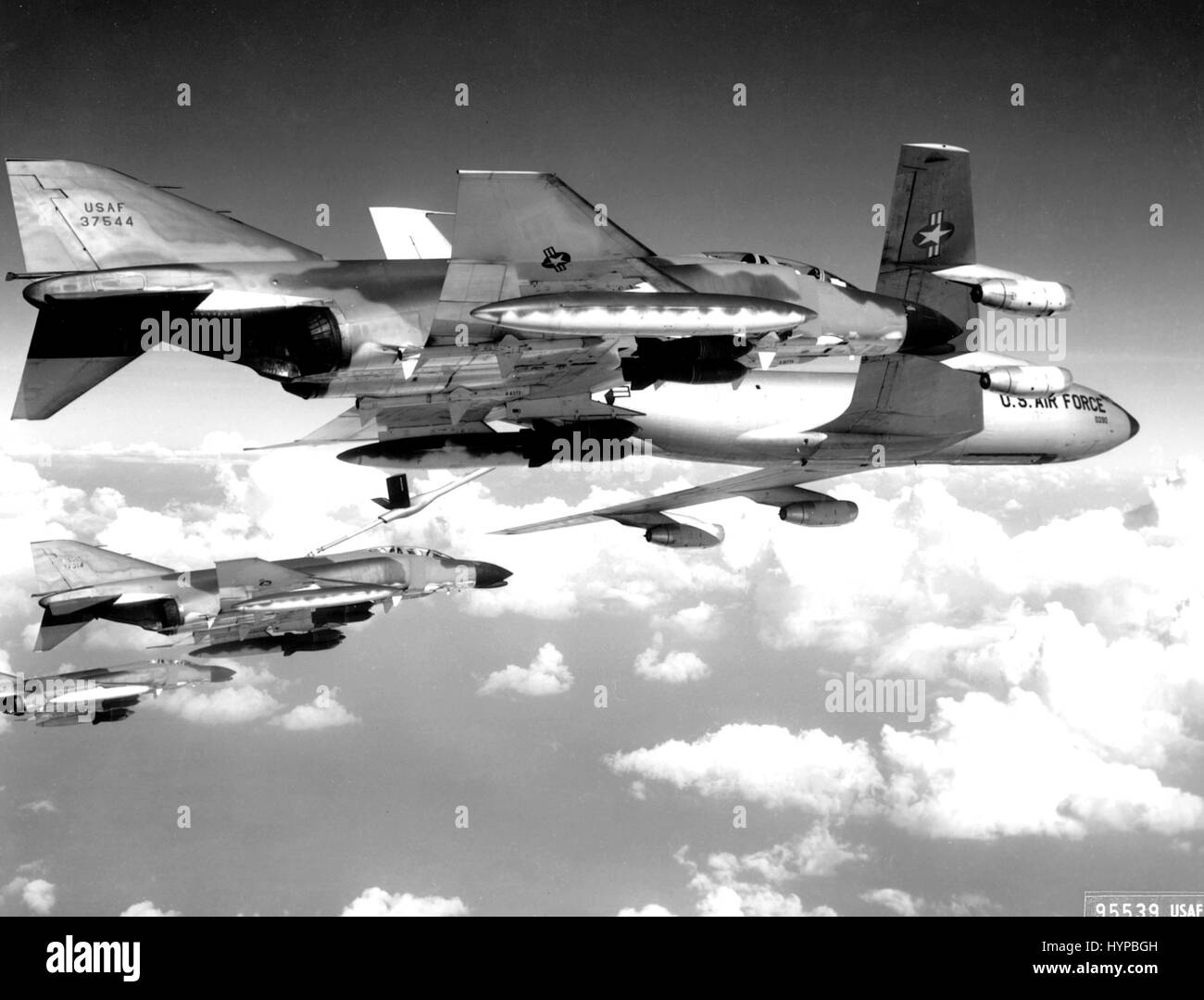 A flight of U.S. Air Force F-4C Phantom fighter bombers refuel from a KC-135 tanker aircraft prior to making a strike against communist targets in North Vietnam.  The Phantoms are fully loaded with 750 pound general purpose bombs and rockets, circa 1969. Stock Photo
