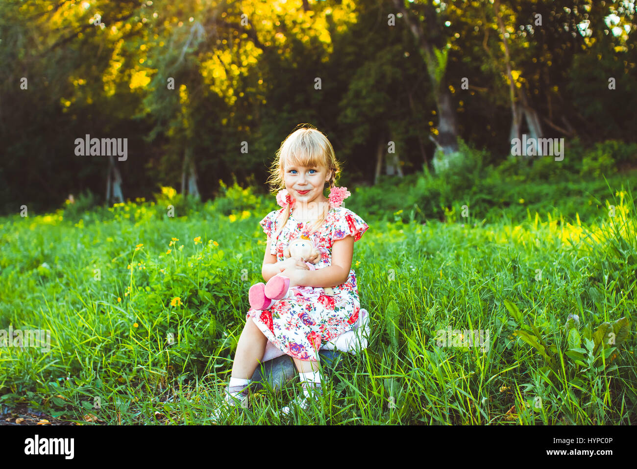 Cute little girl on the meadow in spring day Stock Photo - Alamy