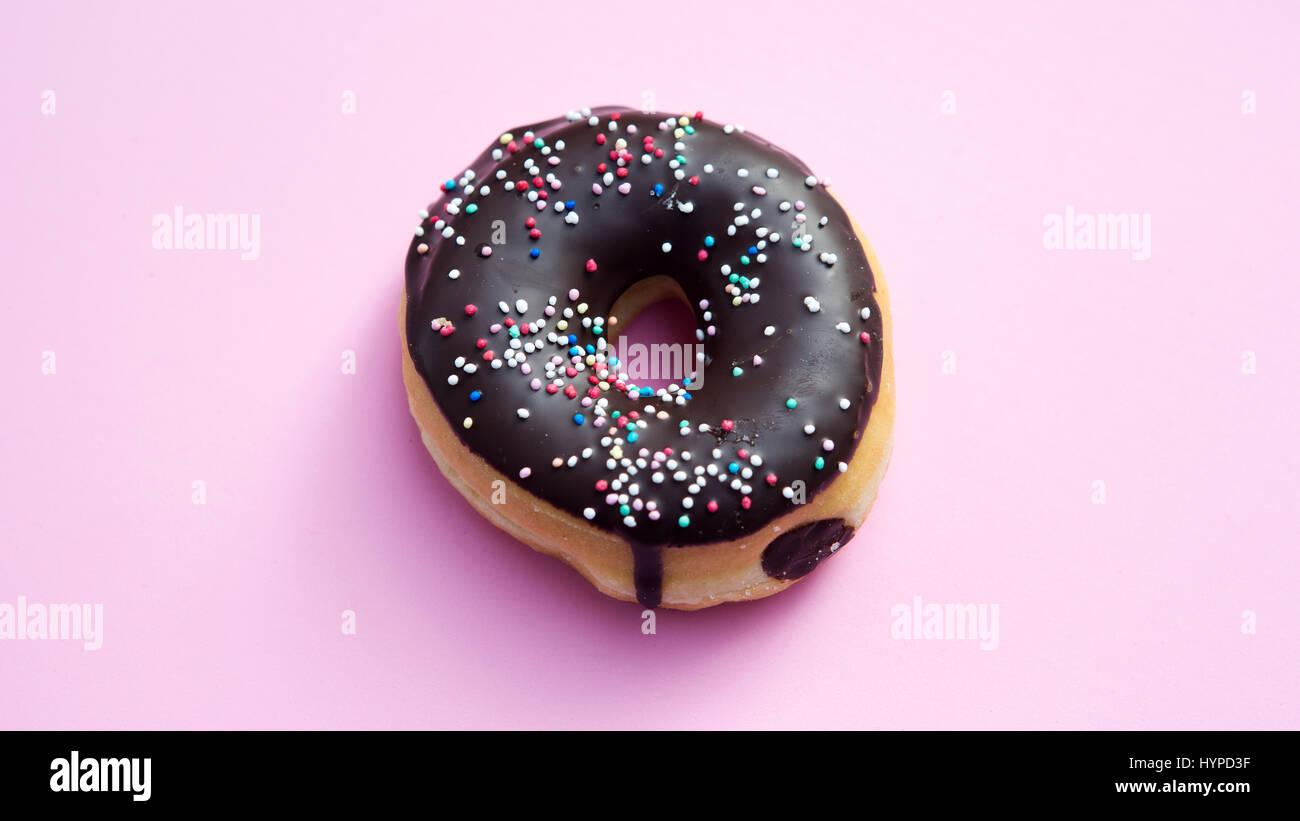 donut with colorful toppings on pink background Stock Photo - Alamy