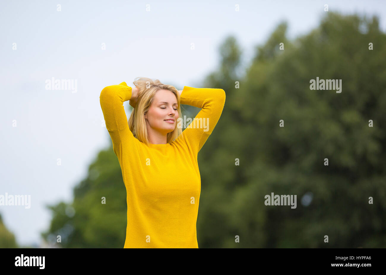Blonde woman breathing fresh air in the park Stock Photo - Alamy