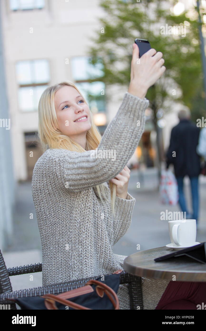 Pretty young woman doing a selfie in a Cafe in city center Stock Photo ...