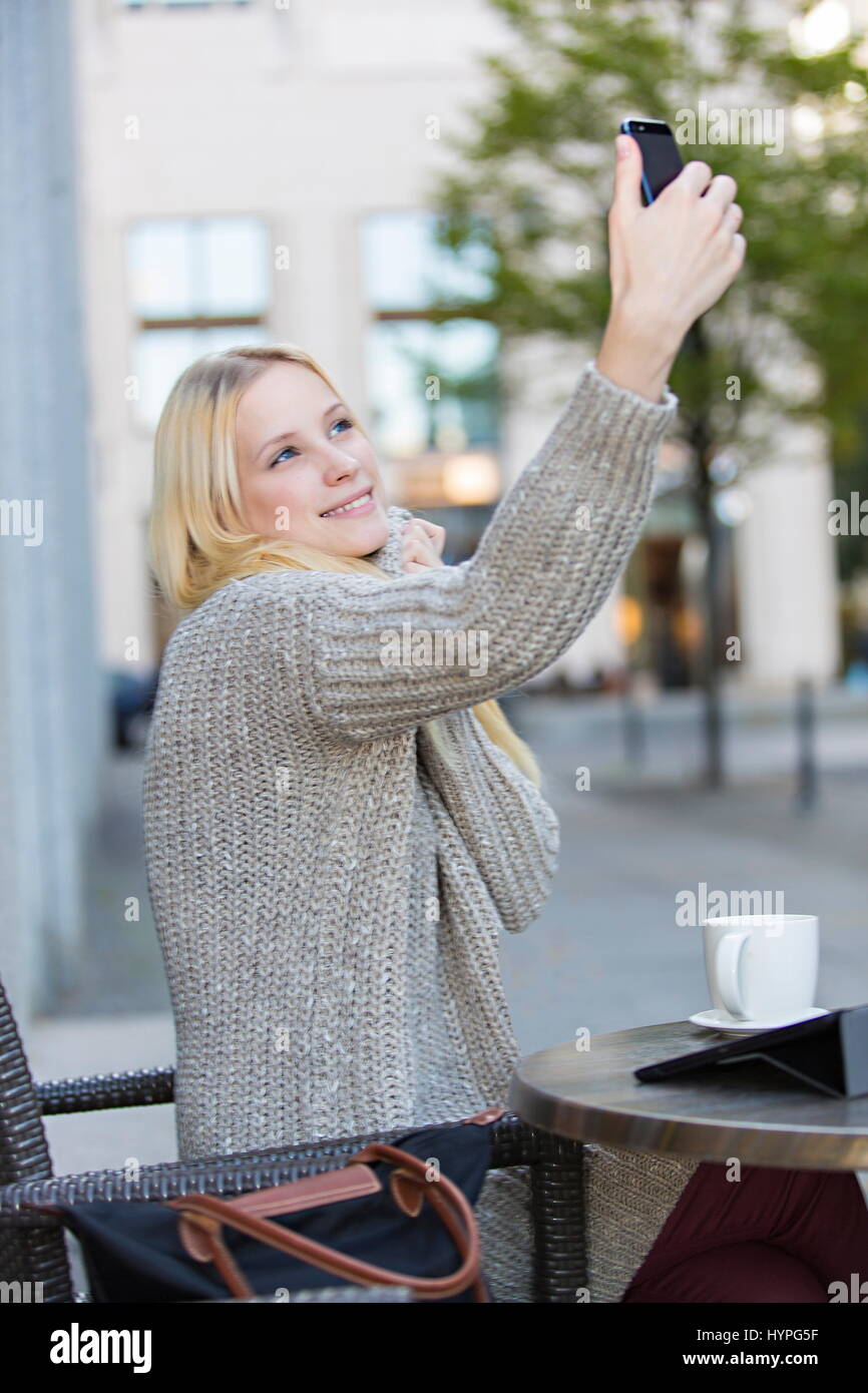 Pretty young woman doing a selfie in a Cafe in city center Stock Photo ...
