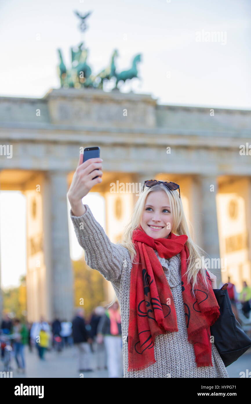 Pretty blonde woman taking a selfie in front of the Brandenburg Gate in ...