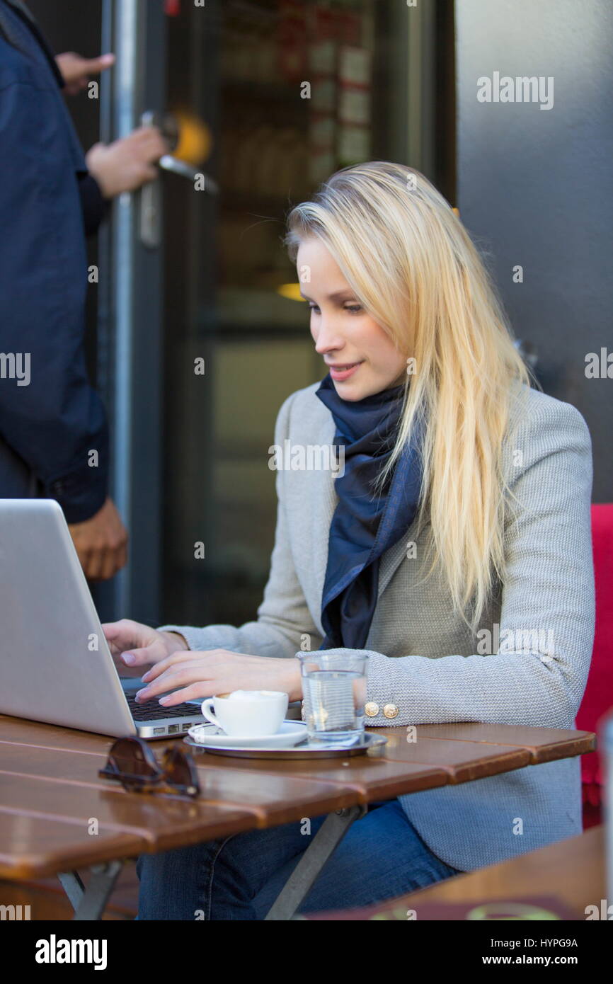 Pretty blonde woman with laptop in a Cafe Stock Photo - Alamy