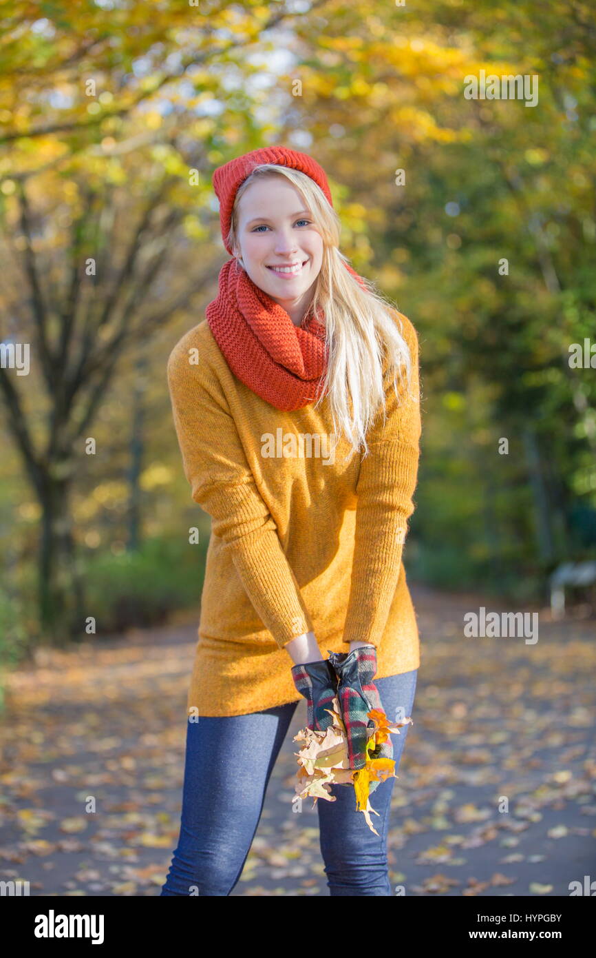 Pretty blonde woman with leaves in park in autumn Stock Photo - Alamy