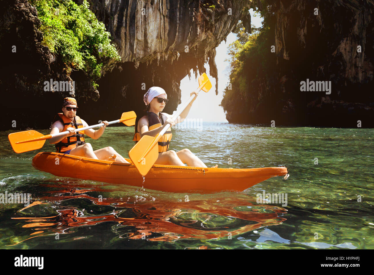 Couple of kayakers swims under the cliff in sea Stock Photo