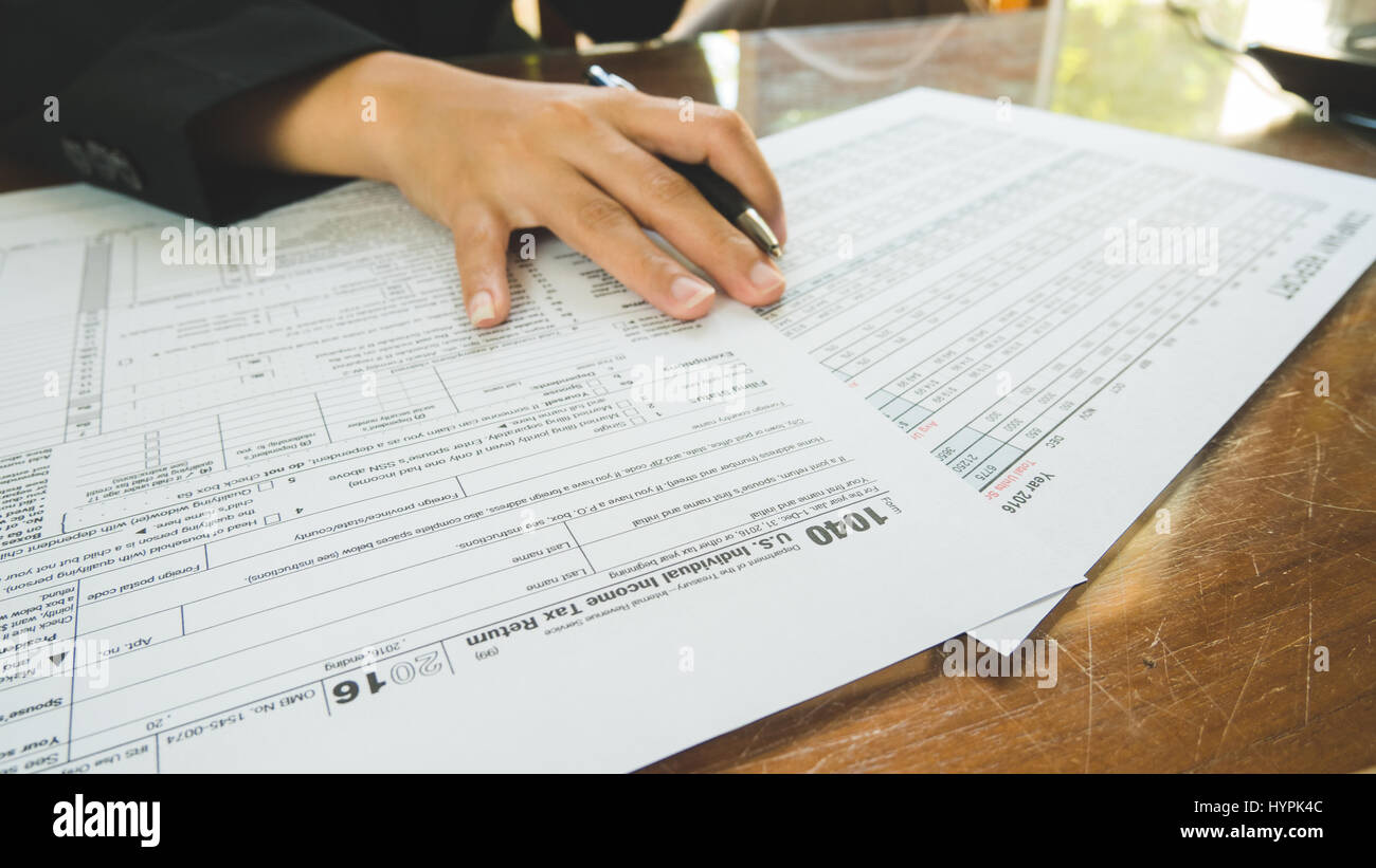 Business woman hand hold on the tax forms paper in business concept Stock Photo