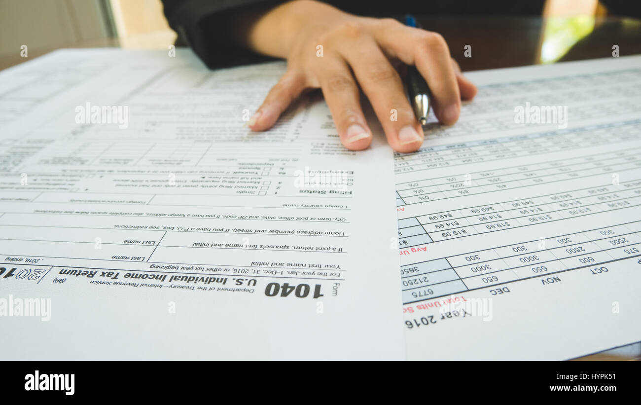 Business woman hand hold on the tax forms paper in business concept Stock Photo