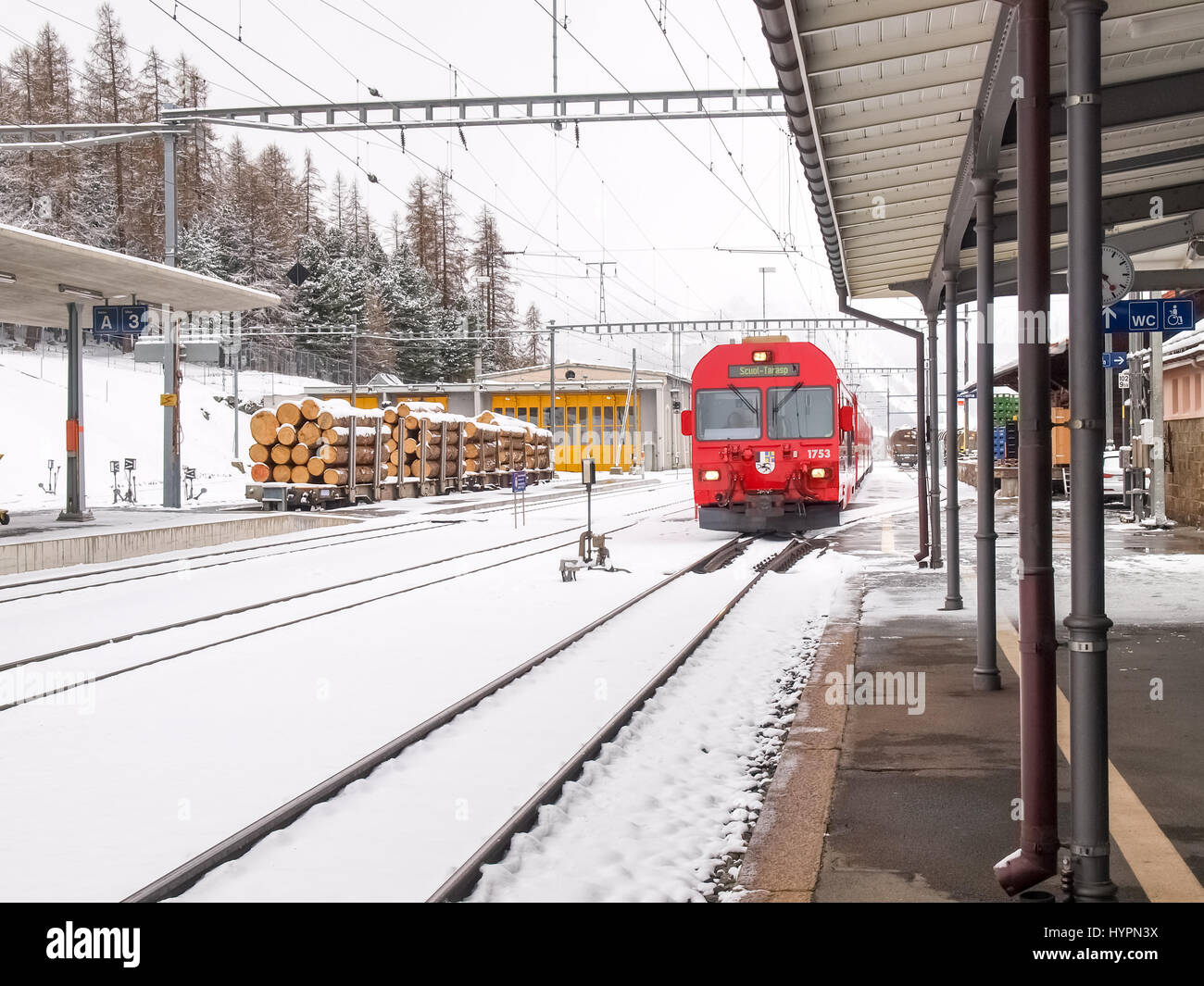 Poschiavo, Switzerland - April 27, 2016: Train of the Rhaetian Railway in transit at the Poschiavo station during a snowy day. Stock Photo