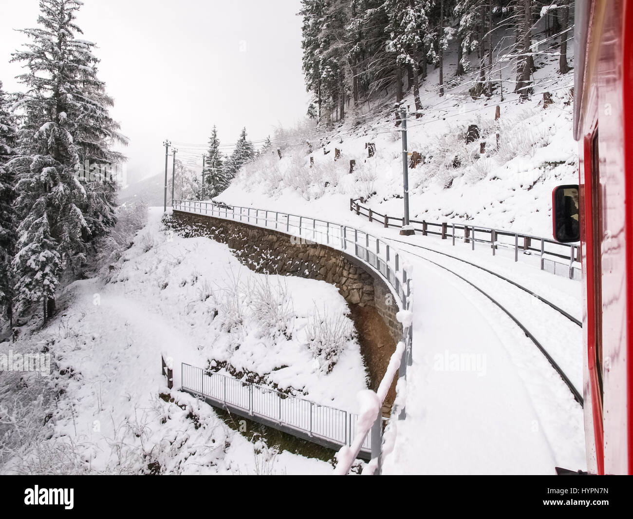 Bernina, Switzerland - April 27, 2016: trains of the Rhaetian Railway in transit along the line Tirano - St.Moritz during a snowy day. Stock Photo