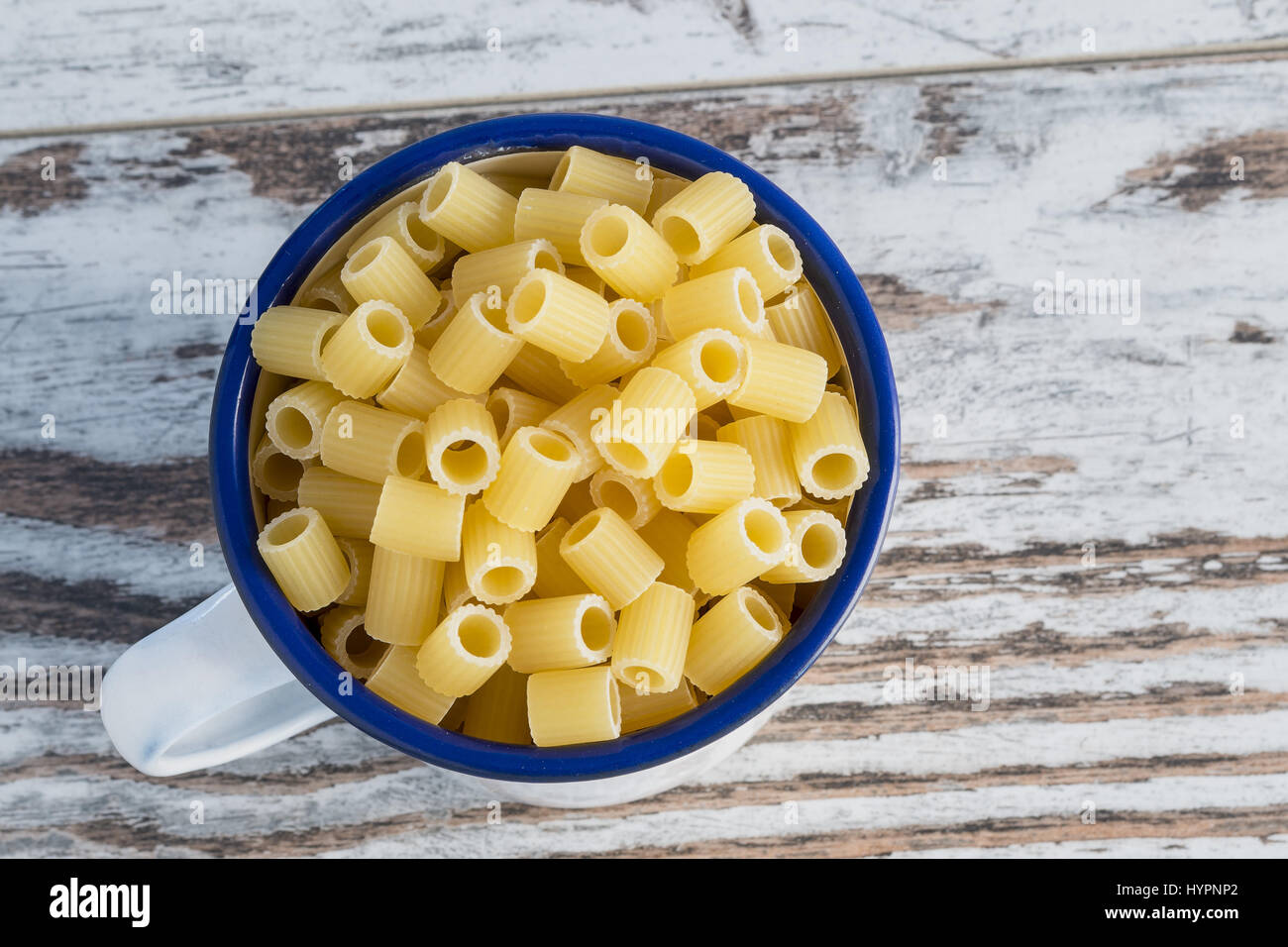 dried pasta in cup metallic fingering Angle Stock Photo