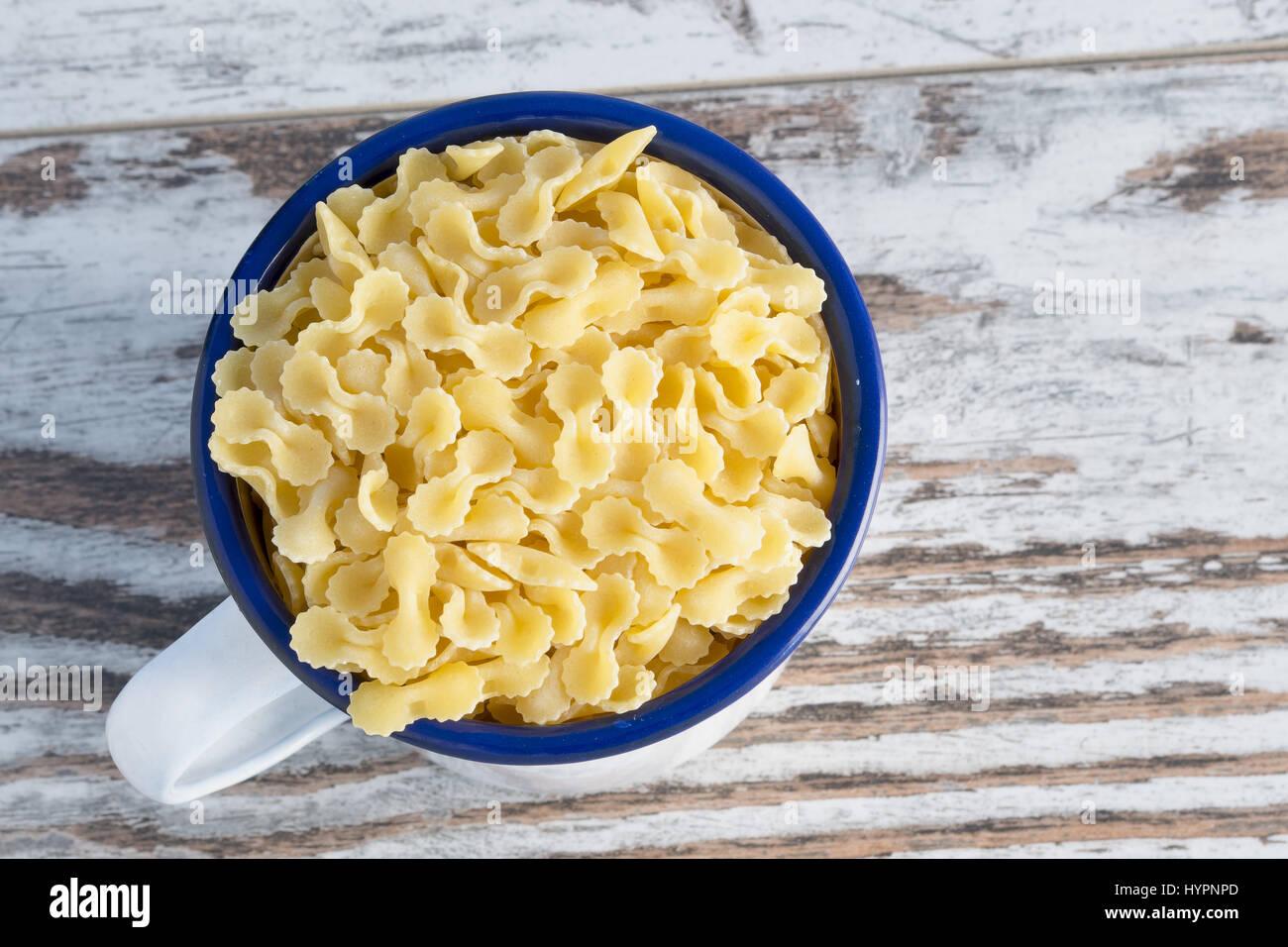 dried pasta in metal cup farfalline Angle Stock Photo