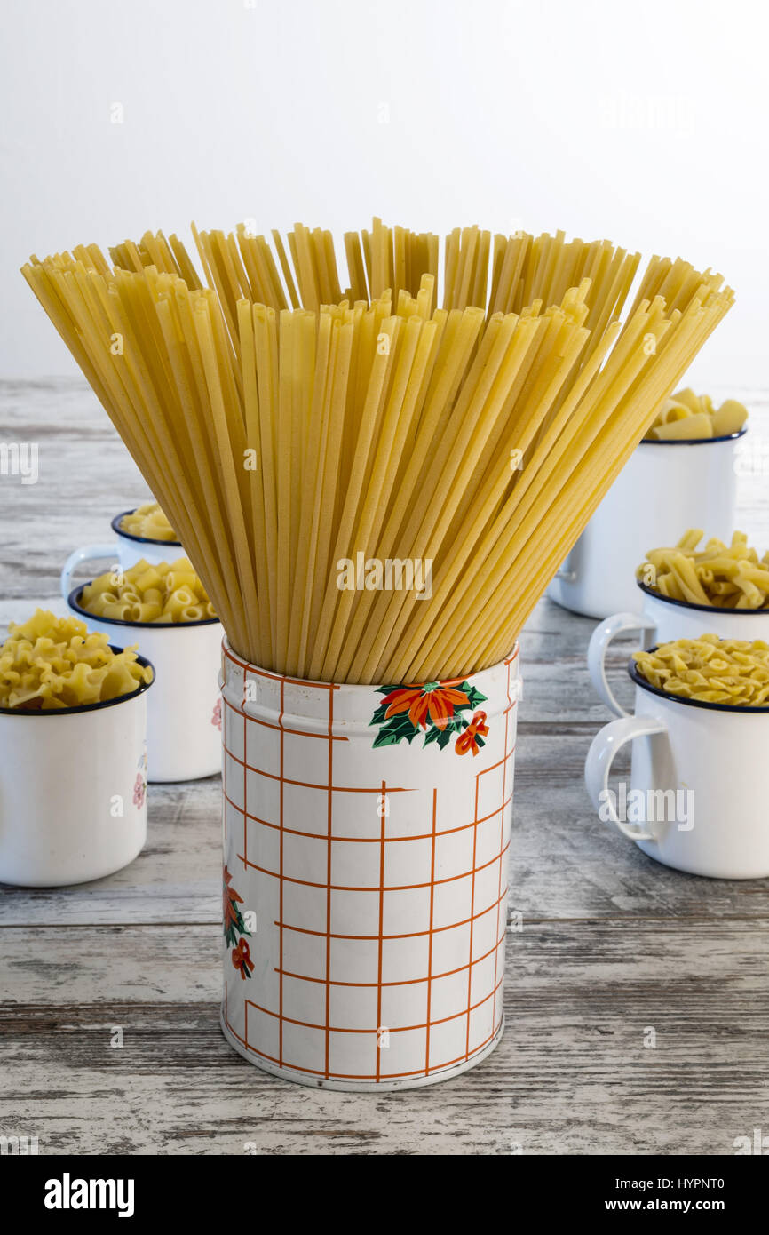 dried pasta in front of metallic tin linguine Stock Photo