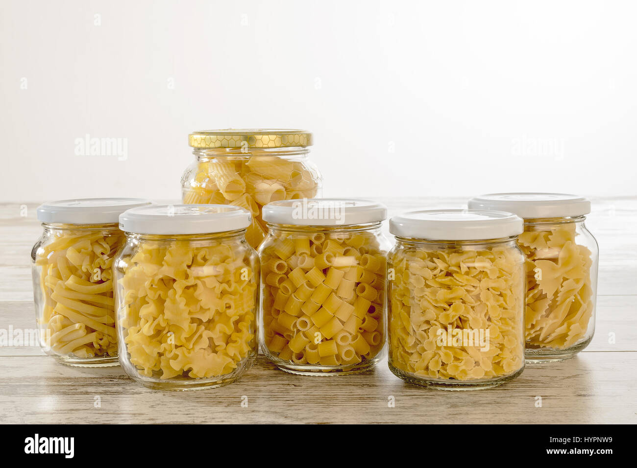 short dry pasta in glass jars with front cover Stock Photo