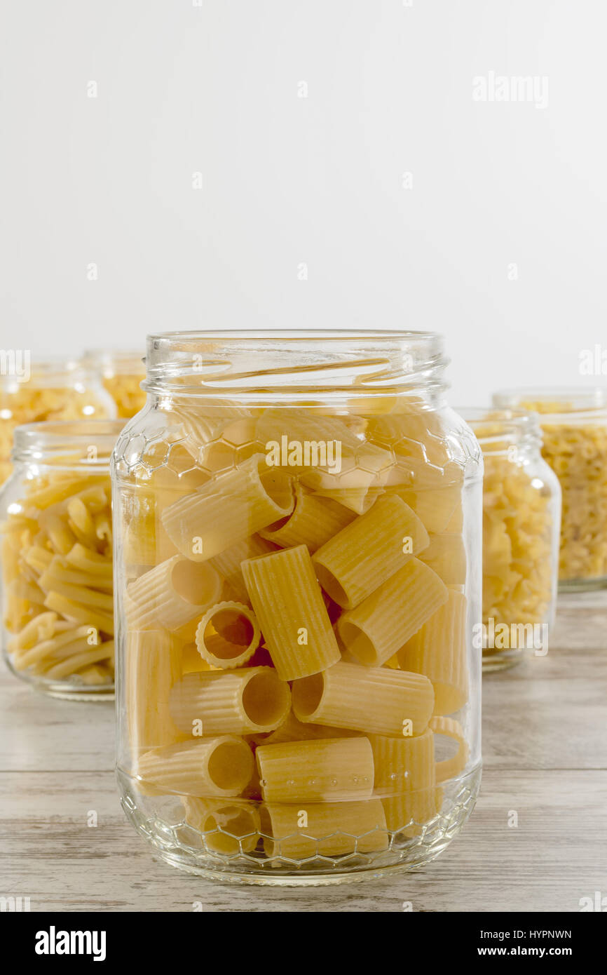 short dry pasta in glass jar half sleeves ribbed front Stock Photo
