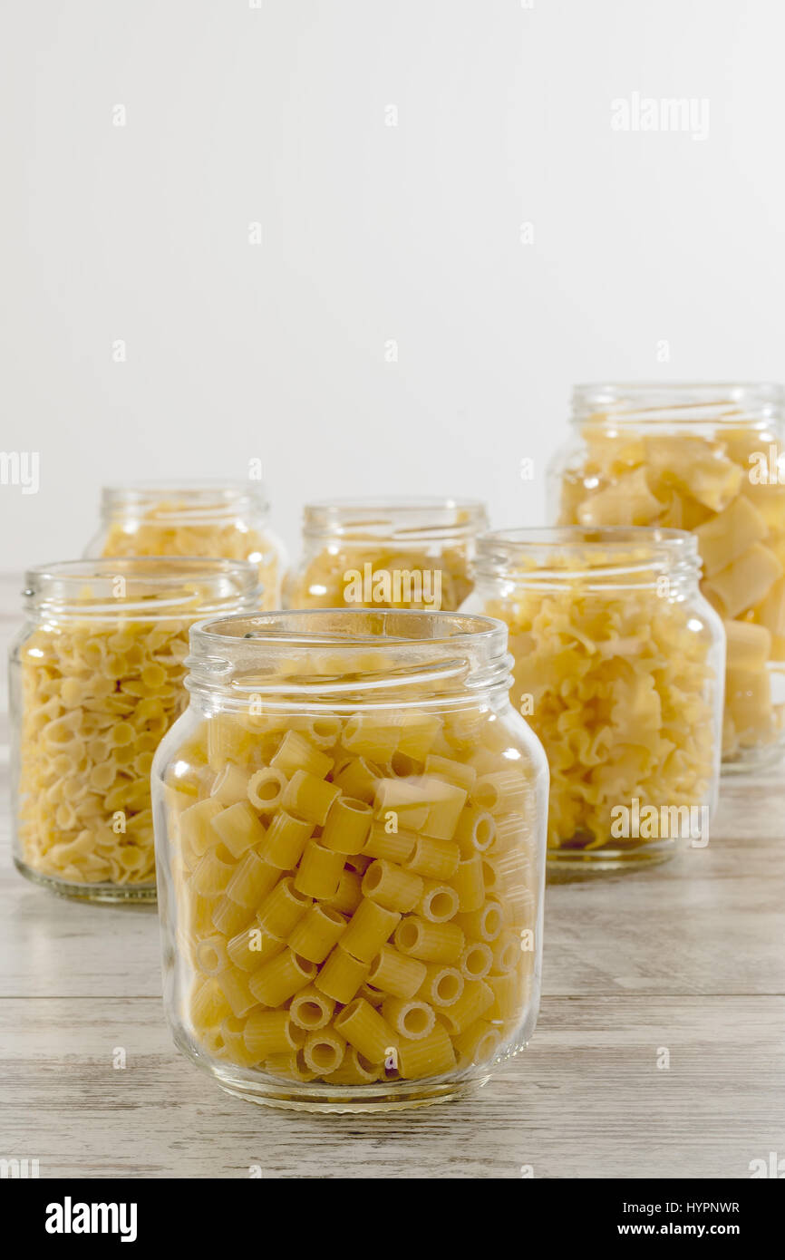 short dry pasta in glass jar fingering front Stock Photo