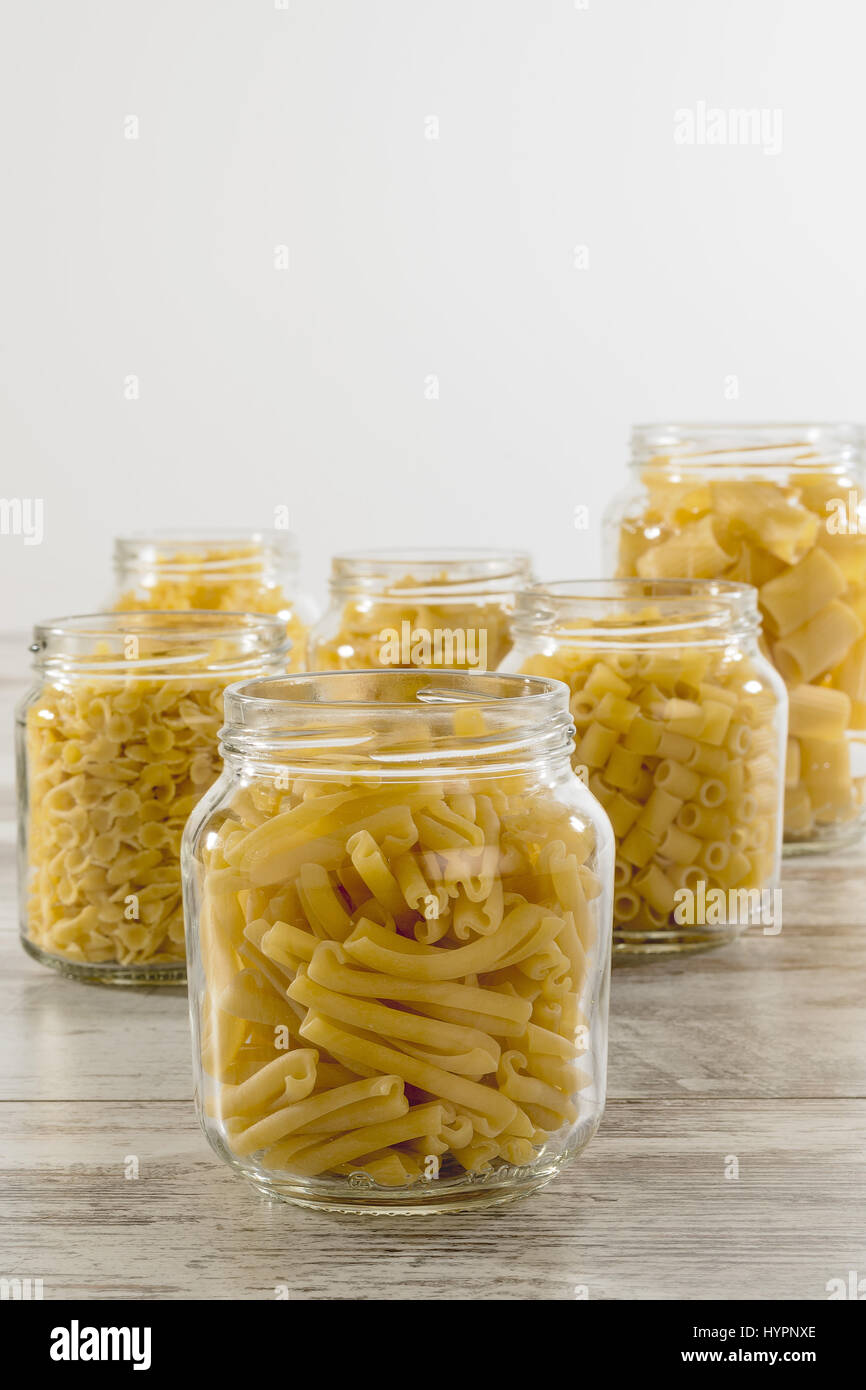 short dry pasta in glass jar twins face Stock Photo