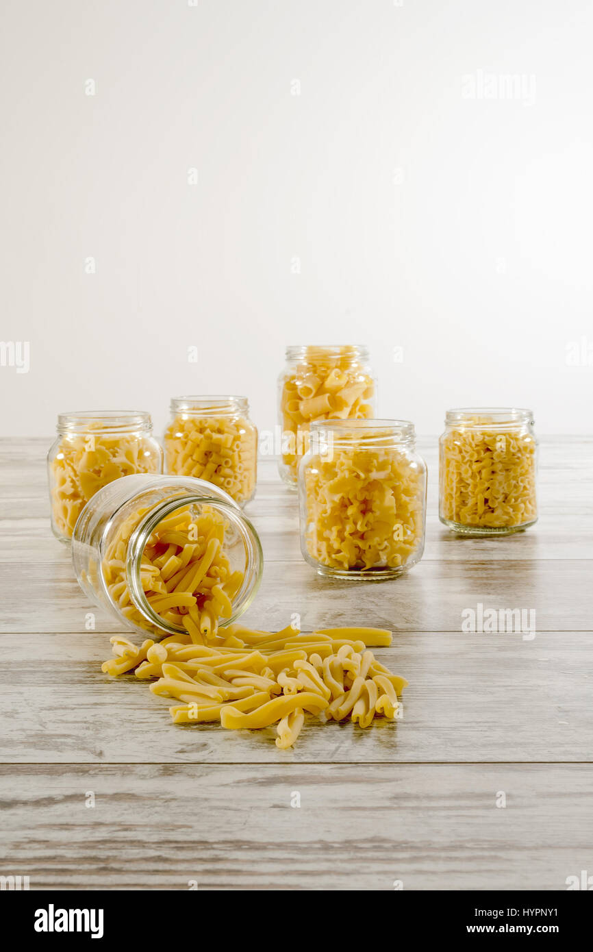 short dry pasta in glass jar overturned twins face Stock Photo