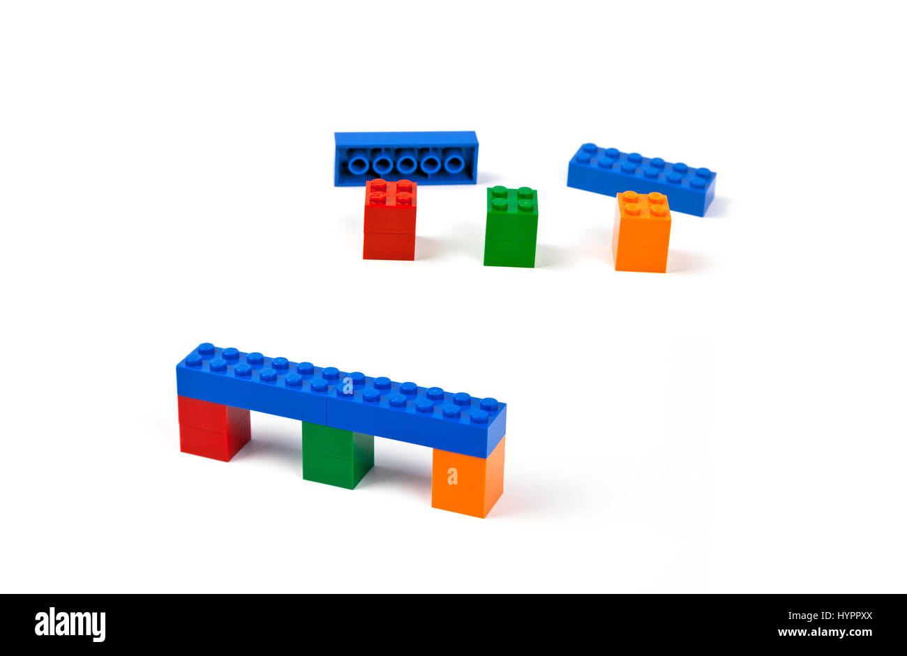 Steps to construct a bridge or viaduct model of Lego pieces. Blue bridge deck resting on three coloured piers. Stock Photo