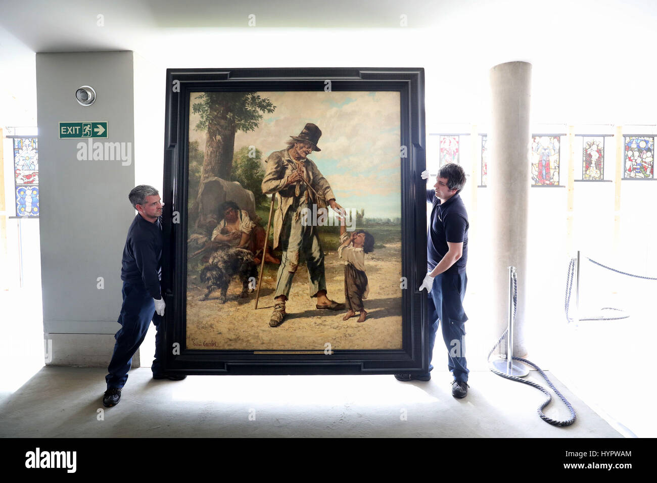 Art technicians Andy Cavanagh (left) and Paul McCall help to move 'The Beggar at Ornans' (1868) by French Realist Gustave Courbet, one of the most recognisable paintings at the Burrell Collection, Glasgow. The painting is one of some 9,000 artworks being taken down to be packed ready to leave the museum while the £66 million refurbishment of building takes place. Stock Photo