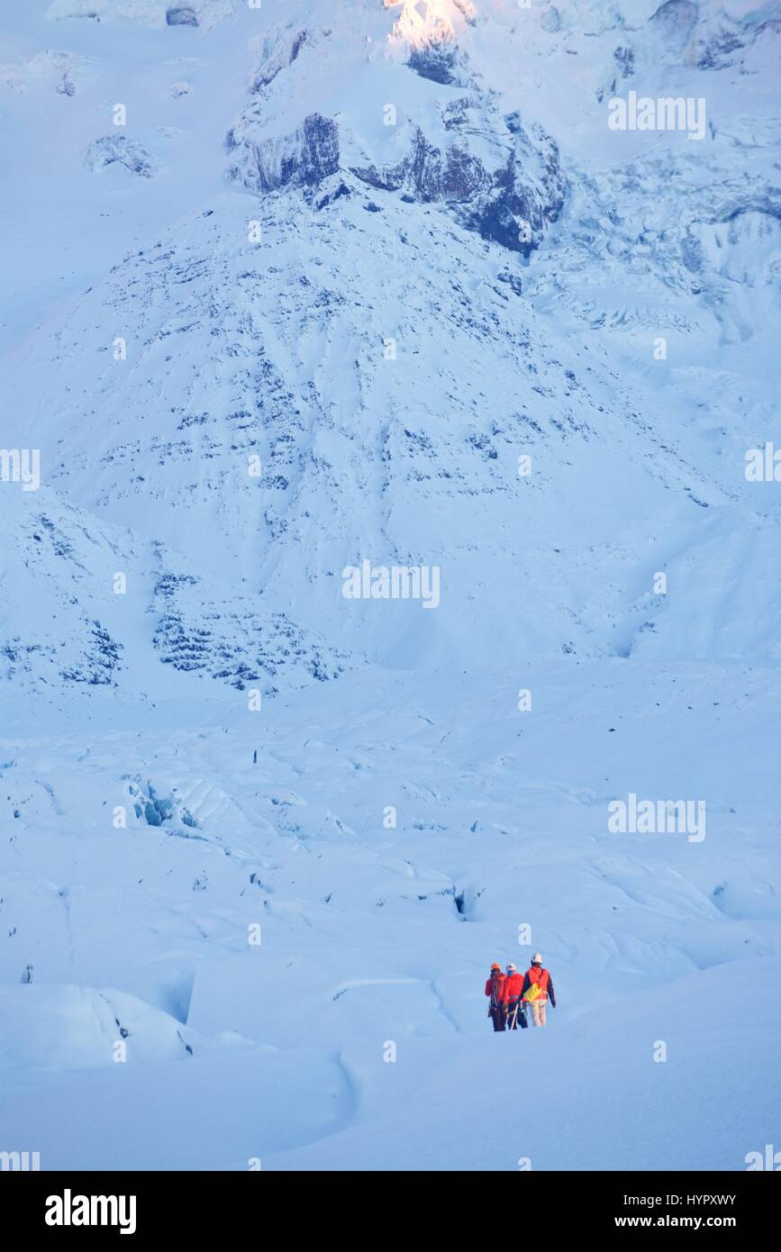 Group of mountaineers trekking through a snow field towards mountains in the southern region of