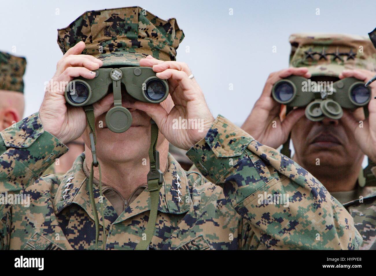 U.S. Marine Corps Commandant Gen. Robert Neller, left, and Army Gen. Vincent Brooks, U.S. and U.N. Forces Korea commander, watches an amphibious assault demonstration with binoculars during at the annual PALS 2017 exercises April 2, 2017 in Pohang, South Korea. PALS is held annually to help strengthen relationships between Indo-Asia-Pacific region Marine and Naval forces. Stock Photo