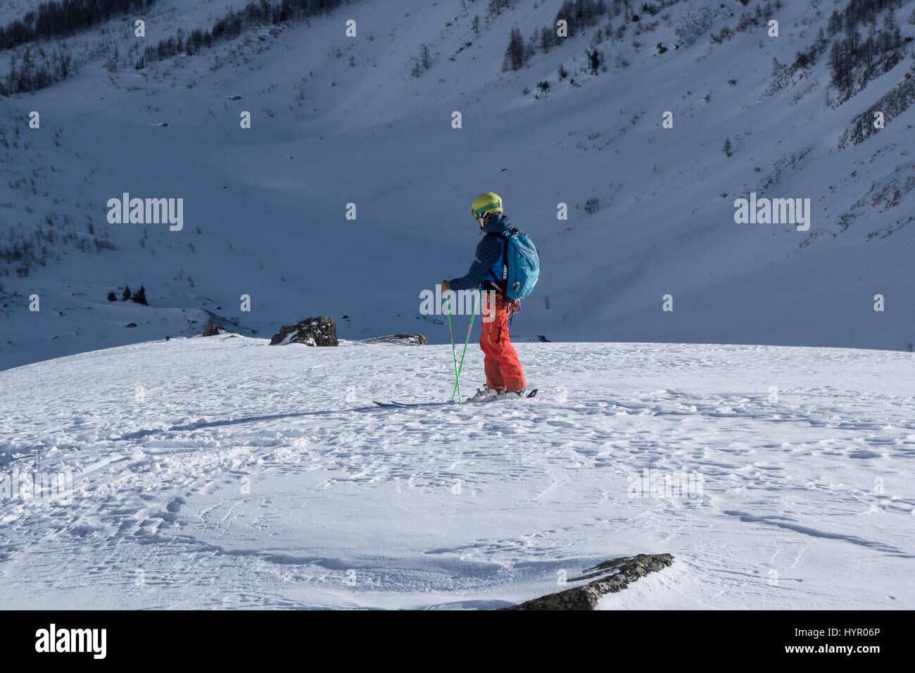Courmayeur, Italy - January 16, 2017: Single skier assessing route choice ahead before sking down into mountain valley Stock Photo