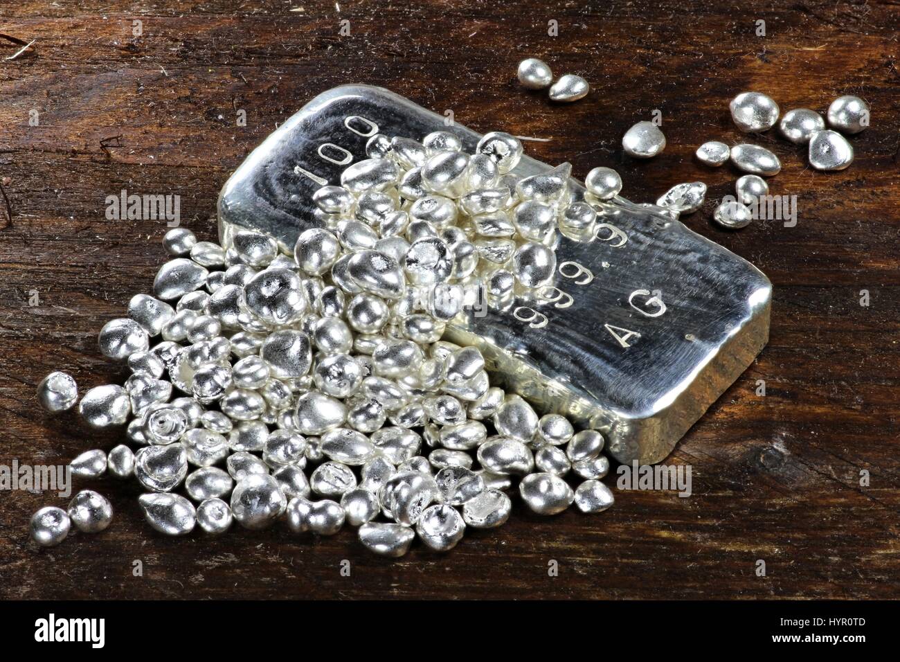 silver ingot and granules on wooden background Stock Photo