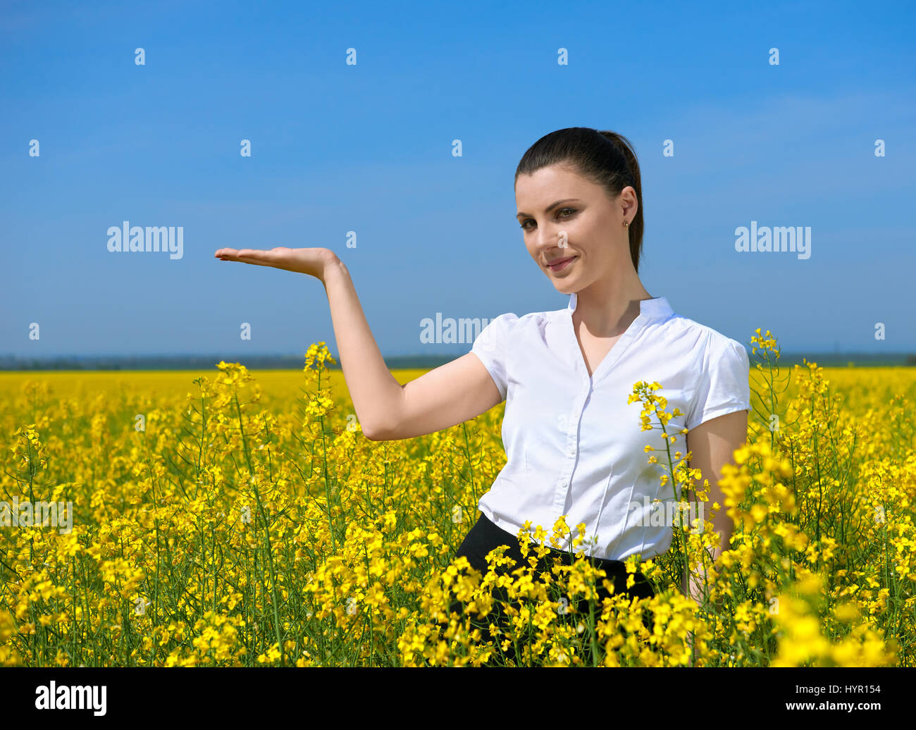 Girl in yellow flower field. Show palm. Hold in palm of something and ...