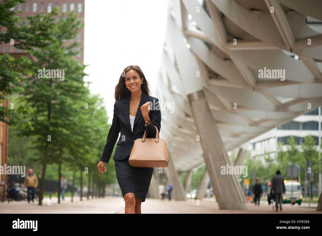 Portrait of a business woman with handbag walking in the city Stock Photo
