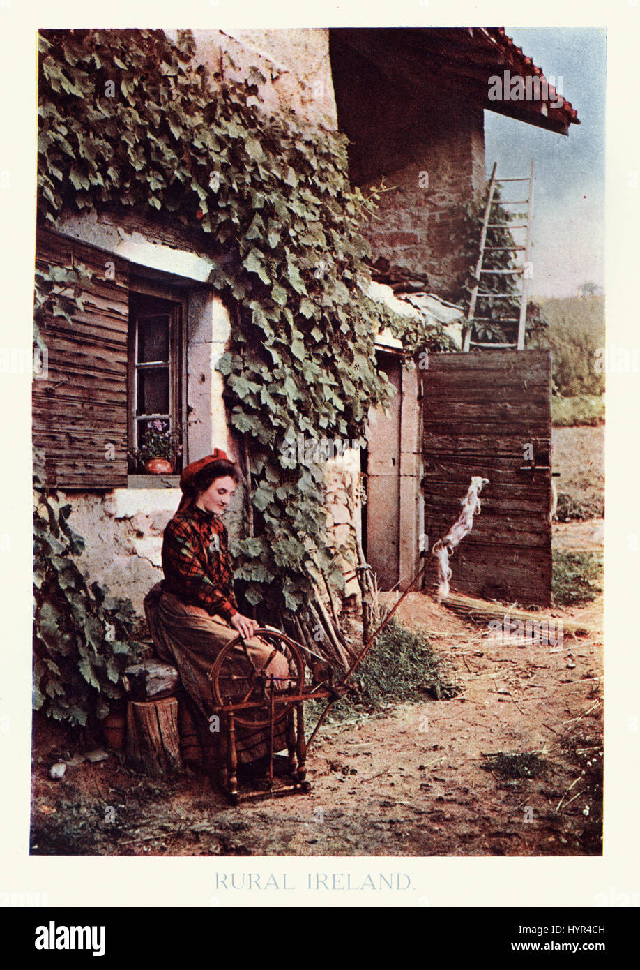 Vintage photograph of a scene from rural Ireland, A young irish woman using a spinning wheel, c.1913 Stock Photo