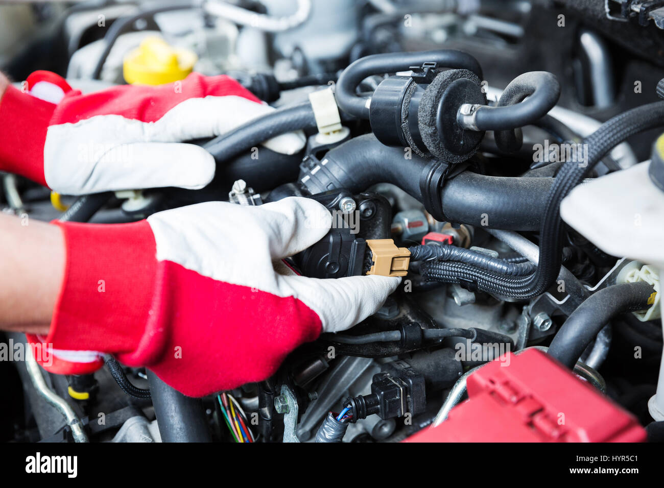 auto mechanic checking car engine electrical connections Stock Photo