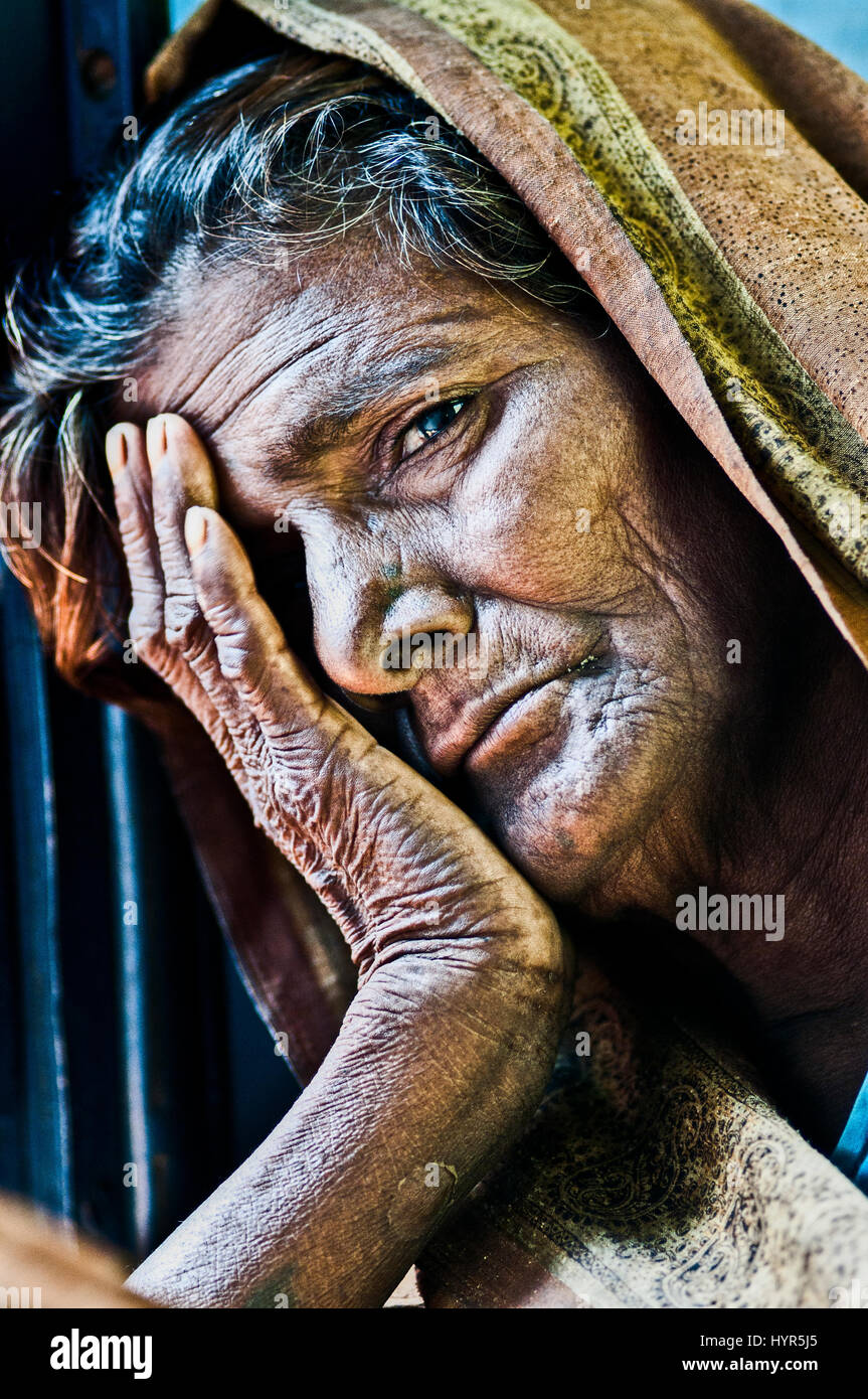 Varanasi, India, septemper 16, 2010: Old indian woman resting her face on her hand looking on a photograpfer. Stock Photo