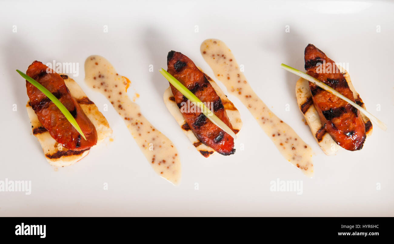 Halloumi cheese and grilled meat starter on white plate Stock Photo
