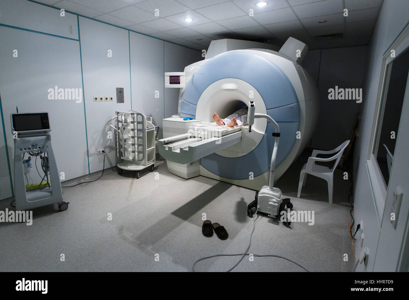 Patient being scanned and diagnosed on a MRI (magnetic resonance imaging) scanner in a hospital. Modern medical equipment, medicine and health care co Stock Photo