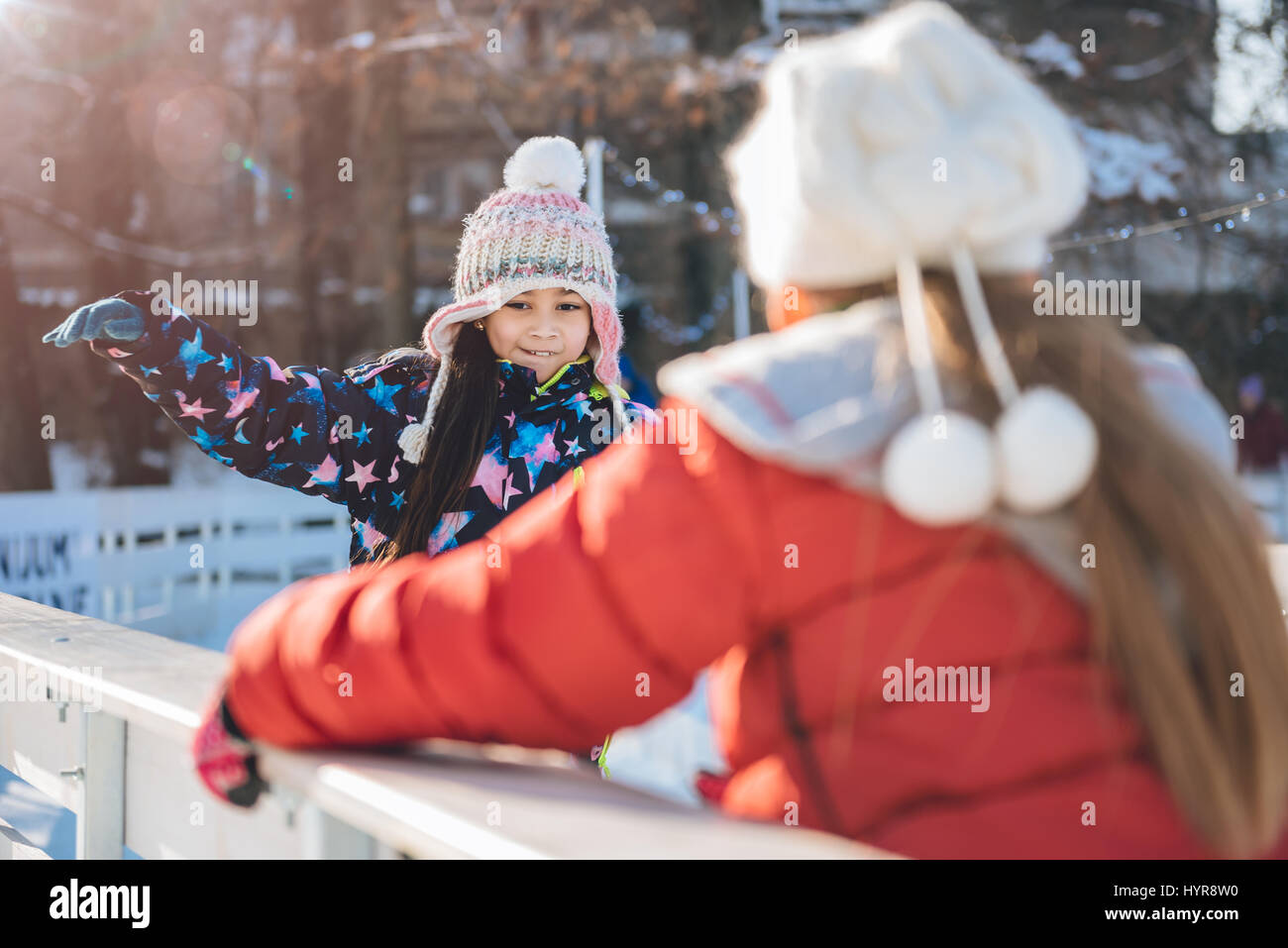 Two girls learning to skate on the temporary ice rink Stock Photo