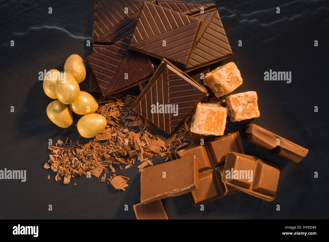 Chocolates and fudge pieces on black slate. Stock Photo